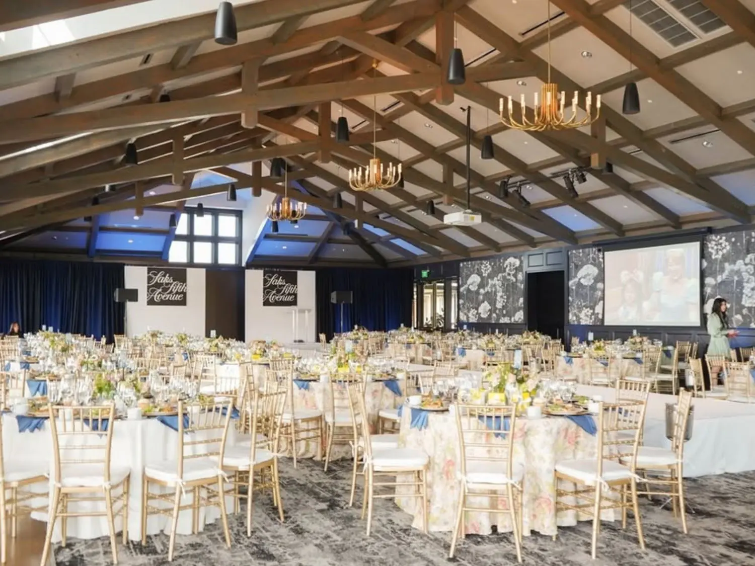 The Red Berry Ballroom decorated with white tablecloths, blue napkins and floral center pieces