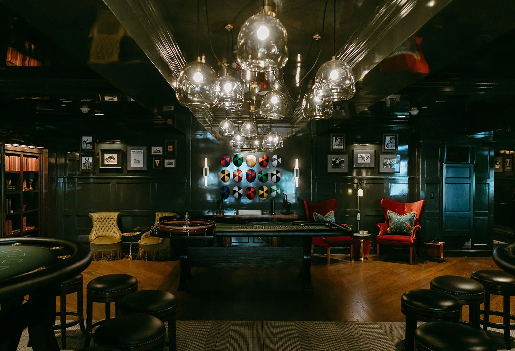 Sophisticated Casino with roulette and card tables, jewel-toned furniture, and statement lighting at The Red Berry Estate.
Photo: Jessie Schultz Photography
