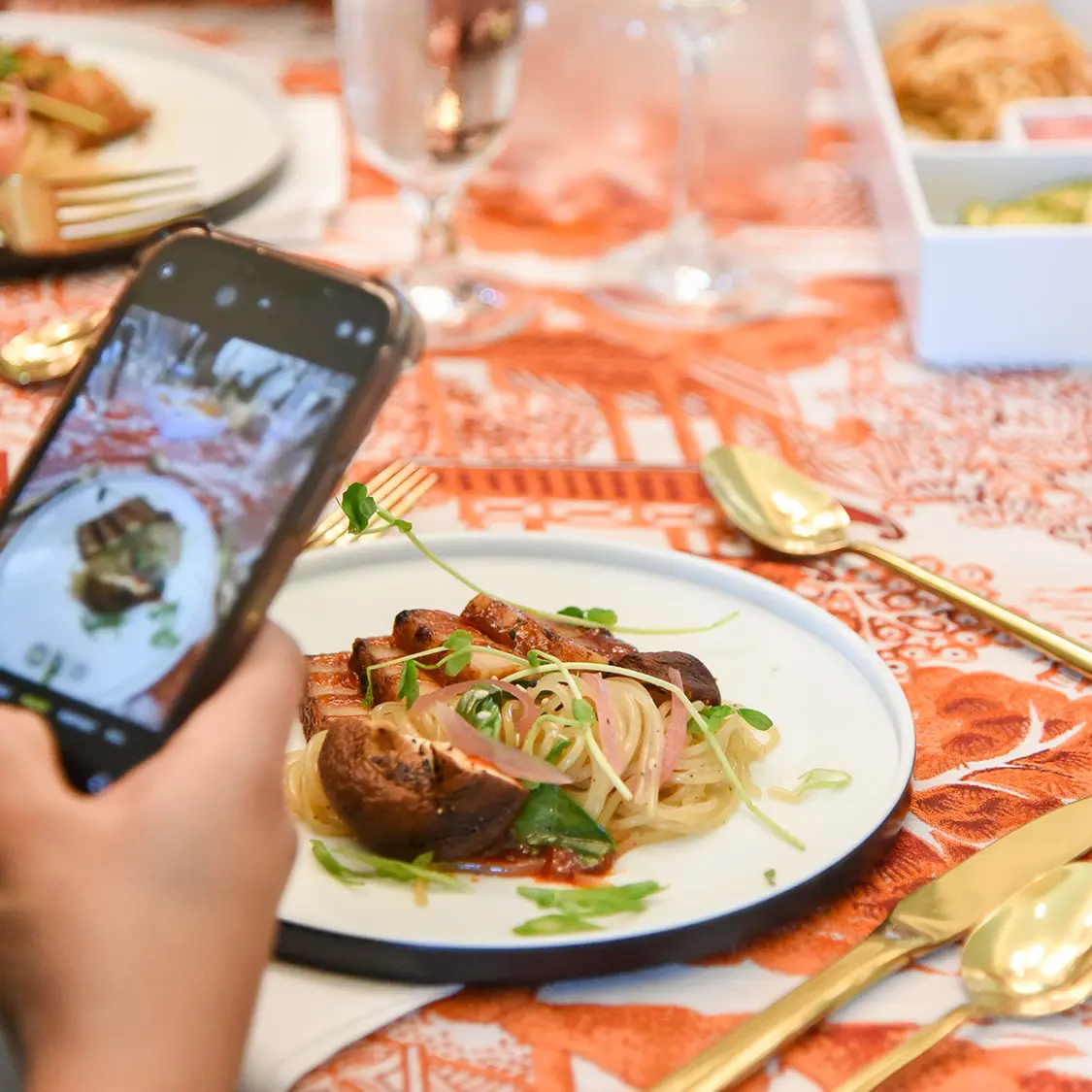 someone taking an iphone picture of their plate of food