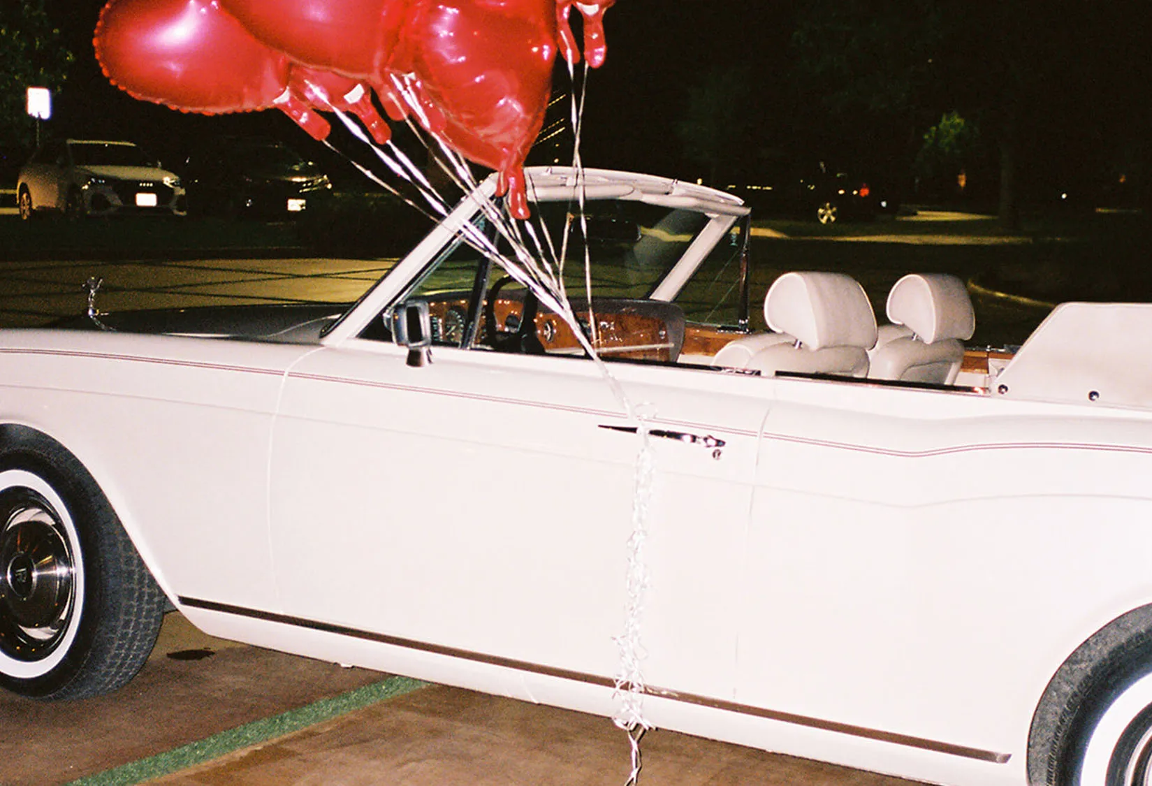 Old White car with balloons, getaway car for newly wed couple
